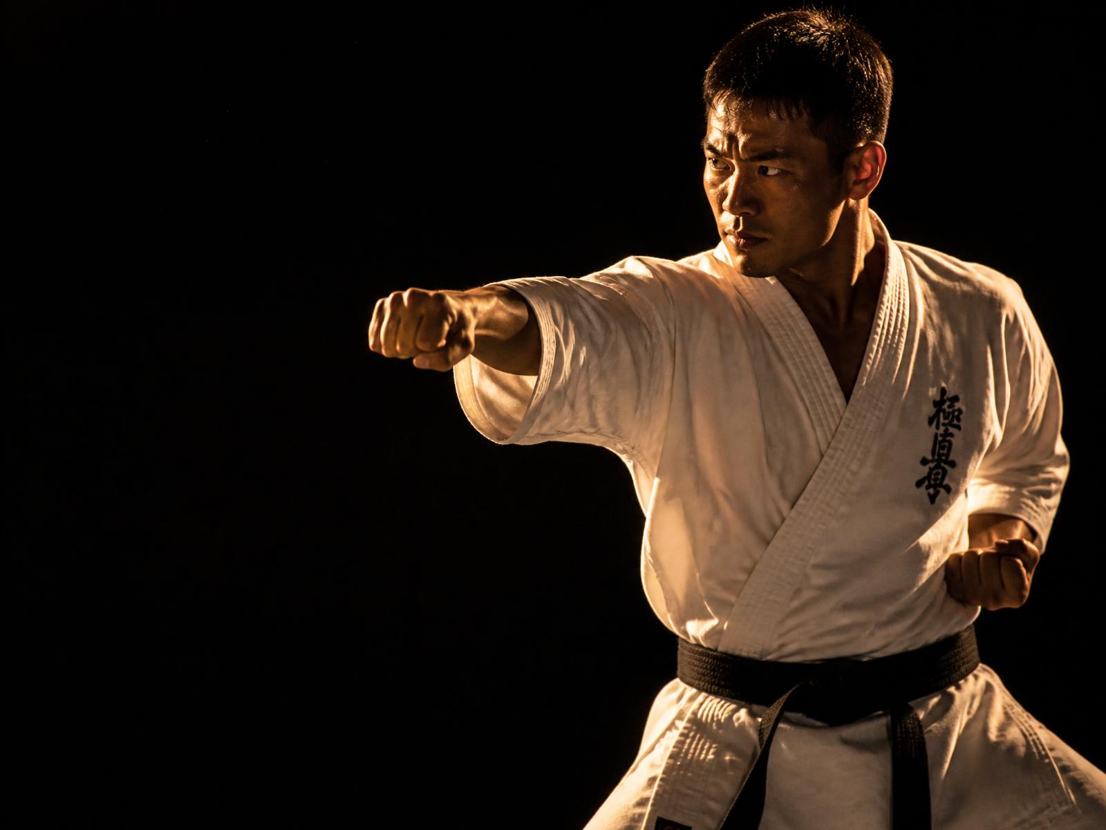 Shotokan karateka in a white gi executing a straight punch
